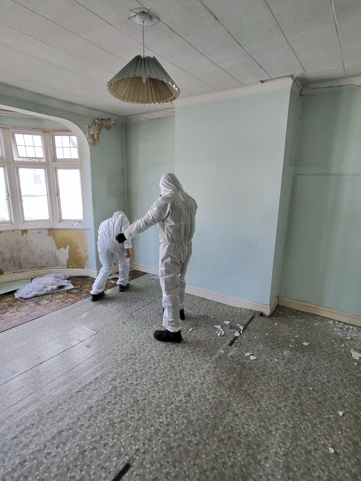 PPE operatives removing asbestos-era flooring – room cleared